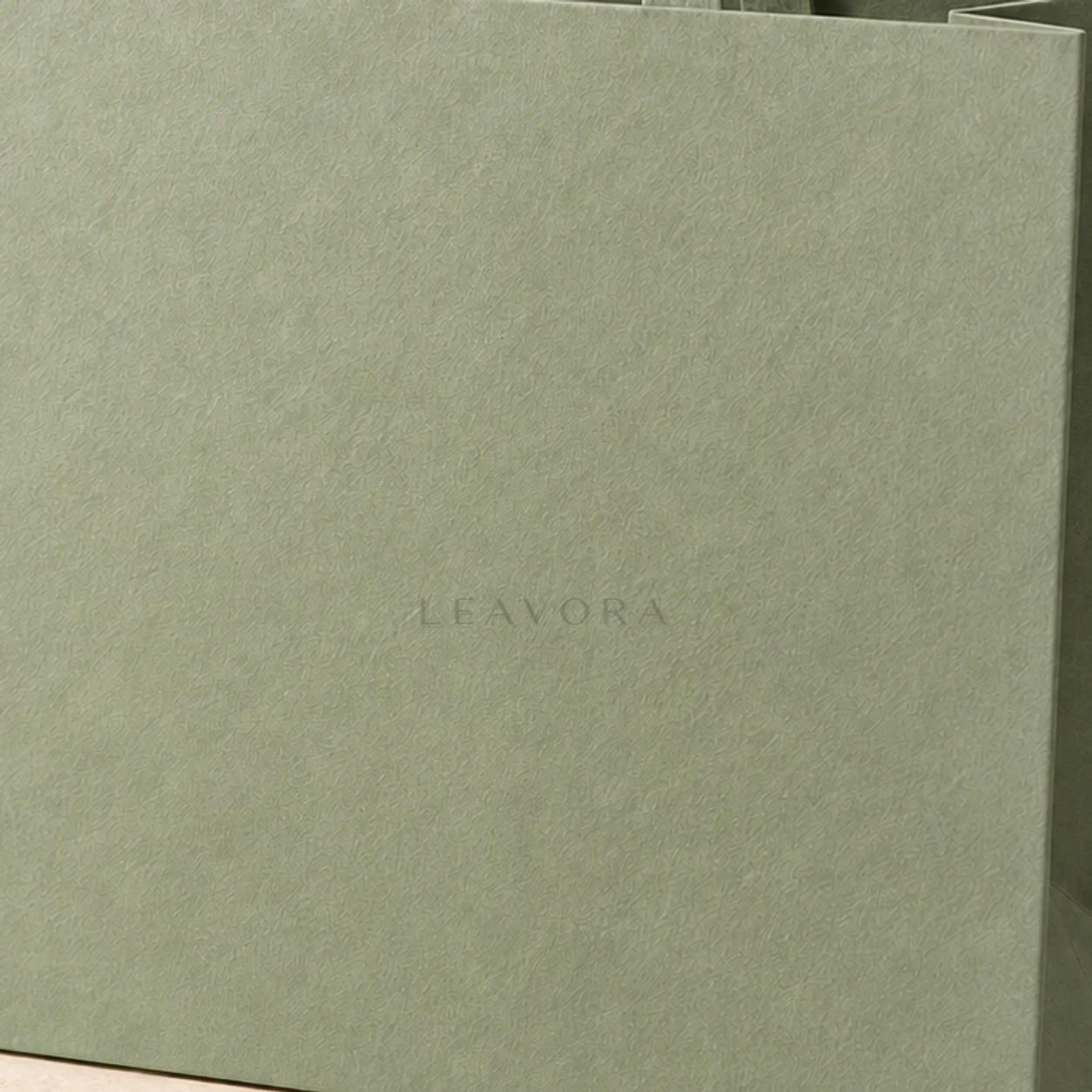 Close-up concept of a restrained embossed LEAVORA mark on a paper bag.